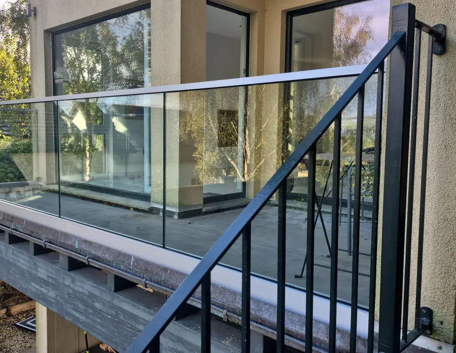 Frameless glass balustrade with a top rail on a first-floor balcony